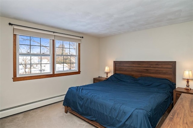 bedroom with baseboard heating and carpet