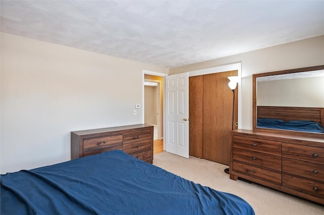 bedroom with a closet and light colored carpet