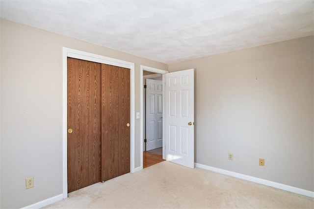 unfurnished bedroom with a closet and light carpet