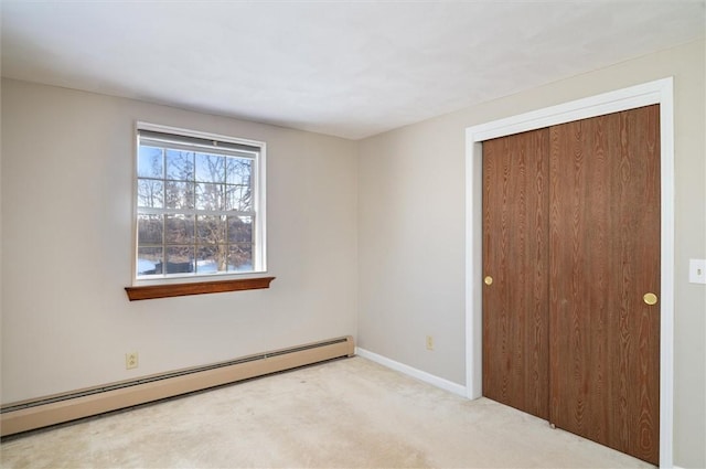 unfurnished room featuring a baseboard heating unit and light carpet