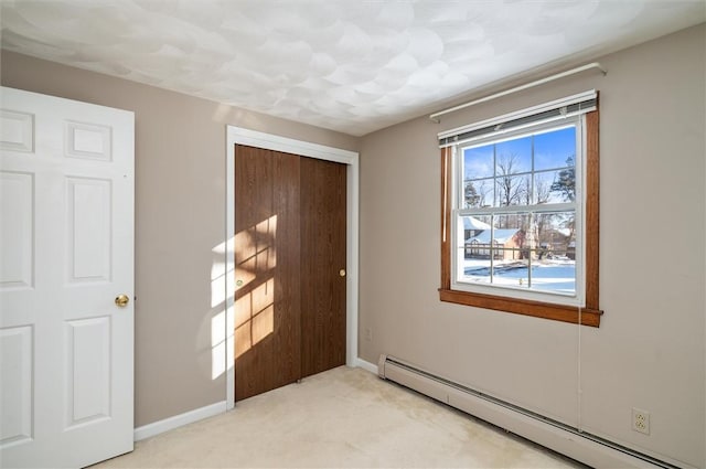 entryway featuring light colored carpet and a baseboard heating unit