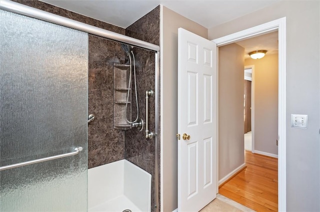 bathroom with hardwood / wood-style flooring and walk in shower