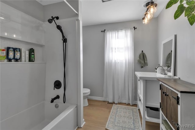 full bathroom with hardwood / wood-style floors, toilet, shower / tub combo, and vanity