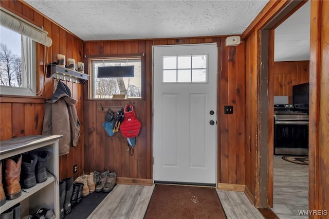 foyer entrance featuring wooden walls and a textured ceiling