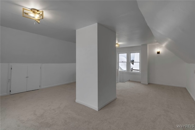 bonus room featuring vaulted ceiling and light colored carpet