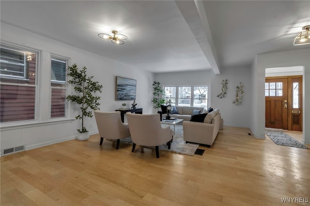 living room with light hardwood / wood-style flooring and beam ceiling