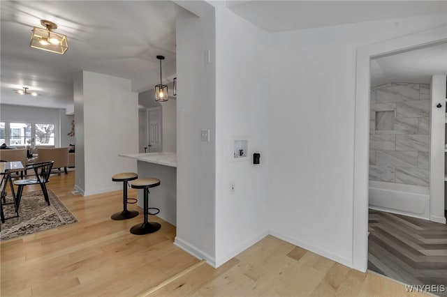 kitchen featuring hardwood / wood-style floors, pendant lighting, and a breakfast bar