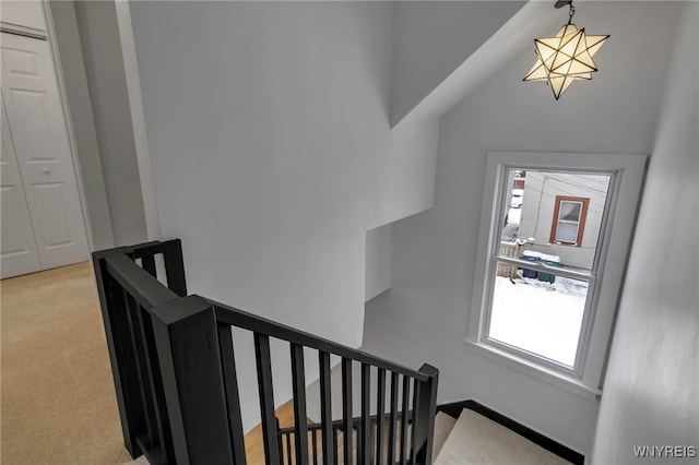 staircase featuring carpet and lofted ceiling