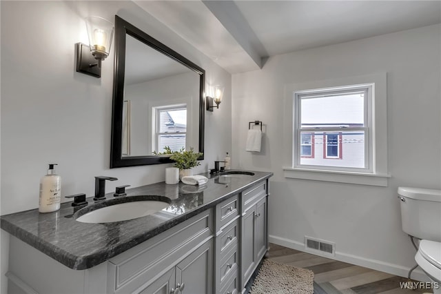 bathroom featuring hardwood / wood-style flooring, toilet, and vanity