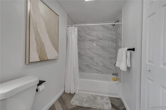 bathroom with toilet, hardwood / wood-style floors, and shower / bath combo with shower curtain