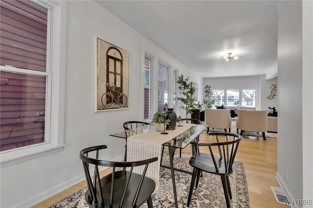 dining space with light hardwood / wood-style floors