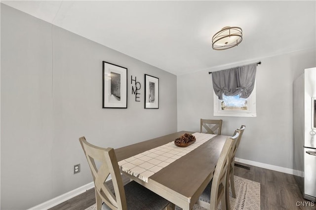 dining space with dark hardwood / wood-style flooring