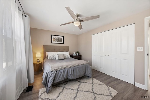 bedroom featuring ceiling fan, dark wood-type flooring, and a closet