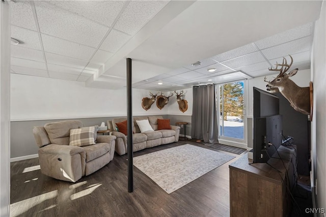 living room with a drop ceiling and dark hardwood / wood-style floors