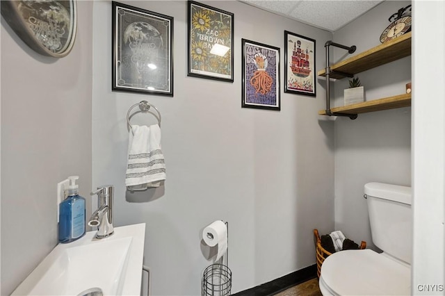 bathroom with sink, a drop ceiling, and toilet