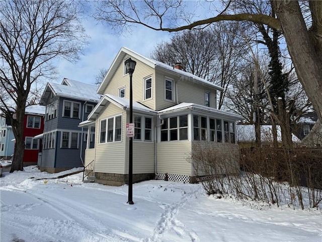 snow covered house with a sunroom