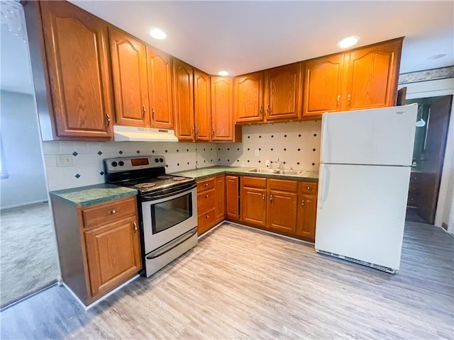 kitchen with sink, white refrigerator, tasteful backsplash, and stainless steel electric range