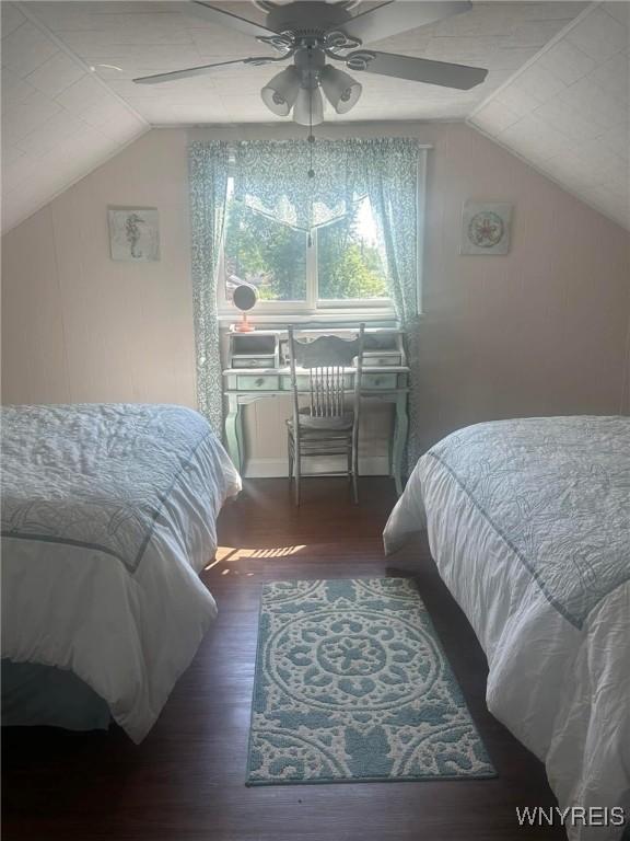 bedroom with ceiling fan, dark hardwood / wood-style floors, and lofted ceiling