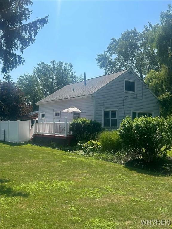 rear view of house featuring a deck and a lawn