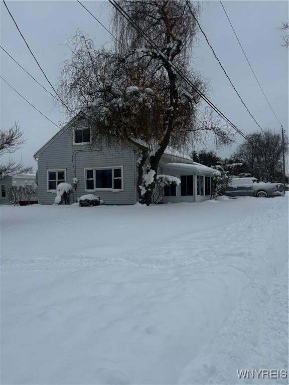 view of snow covered back of property