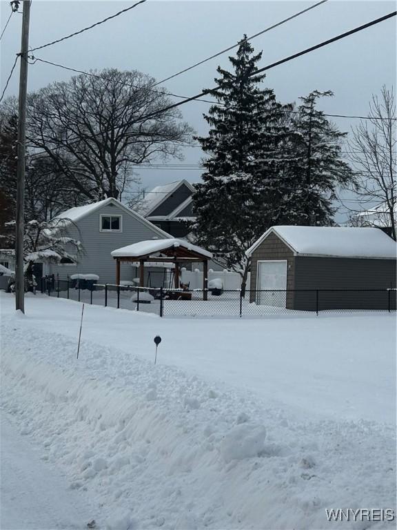 yard covered in snow with a gazebo, an outbuilding, and a garage