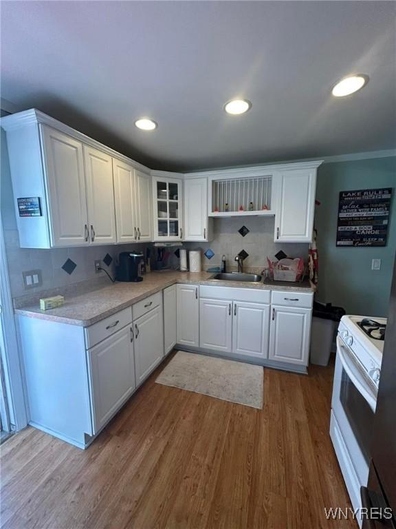 kitchen featuring white cabinets, white range with gas stovetop, and sink