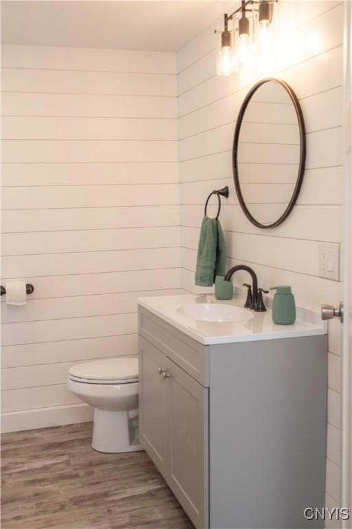 bathroom featuring vanity, toilet, and wood finished floors