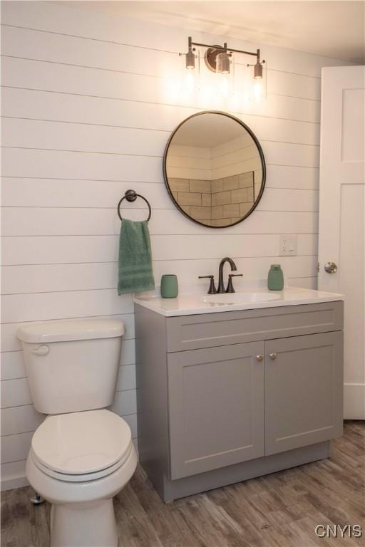 bathroom featuring vanity, toilet, and wood finished floors