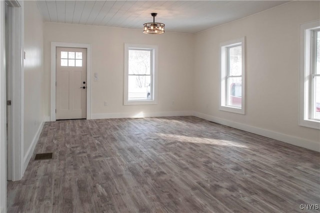 foyer entrance with plenty of natural light, wood finished floors, visible vents, and baseboards