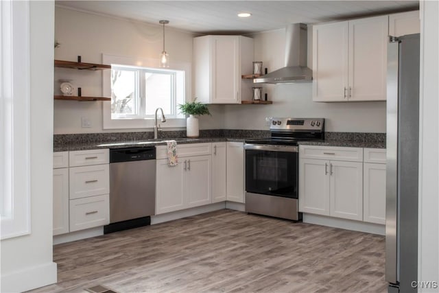 kitchen with white cabinets, appliances with stainless steel finishes, wall chimney range hood, and open shelves