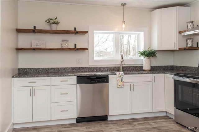 kitchen featuring open shelves, dark stone countertops, stainless steel appliances, white cabinets, and hanging light fixtures