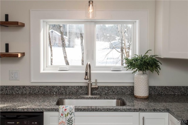 kitchen featuring a sink, black dishwasher, a healthy amount of sunlight, and white cabinetry