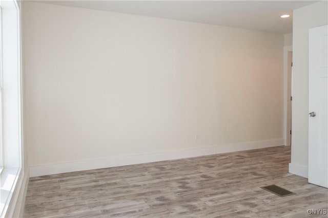 empty room with recessed lighting, visible vents, baseboards, and wood finished floors