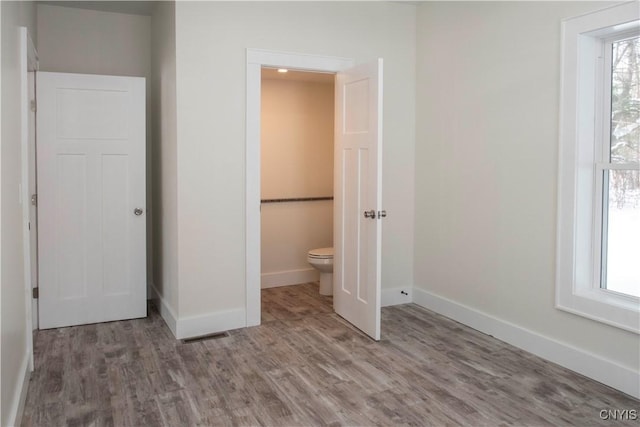 unfurnished bedroom featuring baseboards and wood finished floors