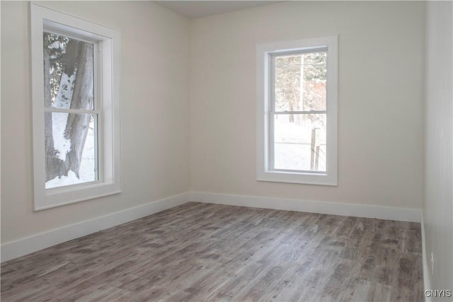 spare room with a wealth of natural light and baseboards