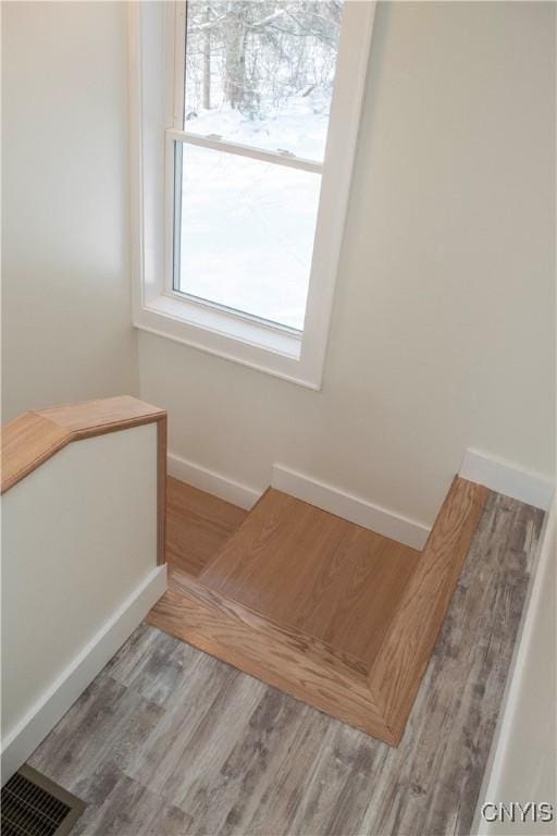 staircase featuring visible vents, baseboards, and wood finished floors