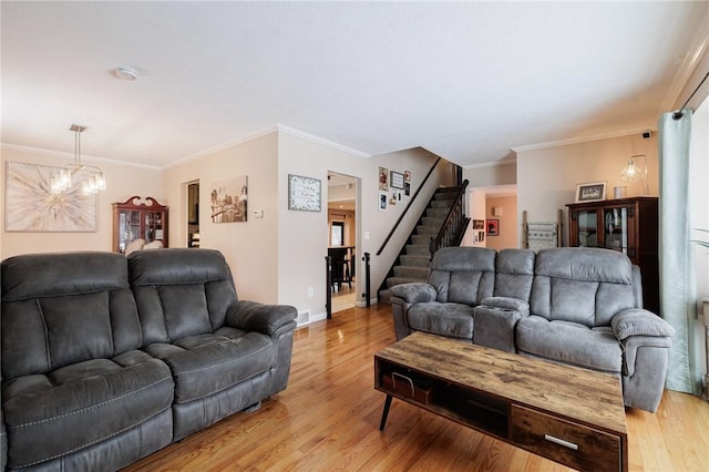 living room with crown molding, light hardwood / wood-style floors, and an inviting chandelier