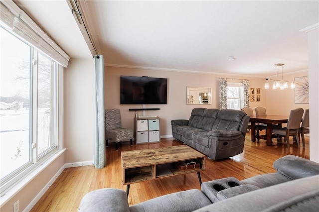 living room featuring crown molding, plenty of natural light, and light hardwood / wood-style floors