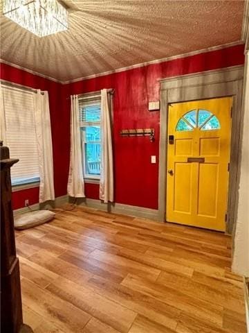 entryway with hardwood / wood-style flooring and ornamental molding