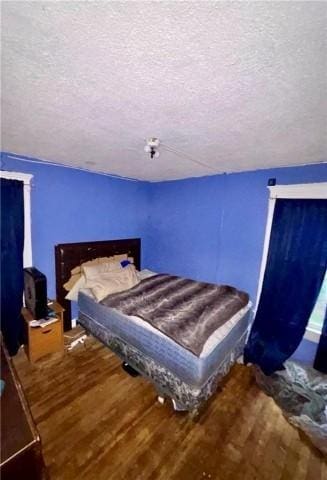 bedroom featuring hardwood / wood-style floors and a textured ceiling