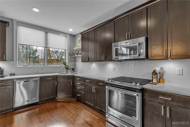 kitchen featuring sink, backsplash, dark brown cabinetry, and stainless steel appliances