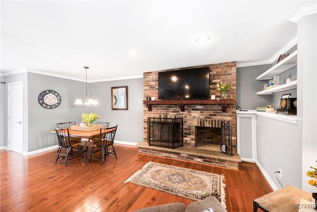 dining room featuring a fireplace, wood-type flooring, and crown molding