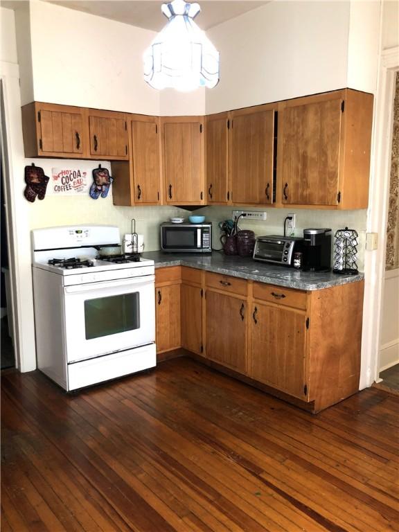 kitchen featuring dark hardwood / wood-style floors and gas range gas stove