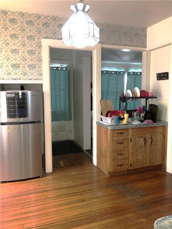 kitchen with dark hardwood / wood-style floors and stainless steel refrigerator