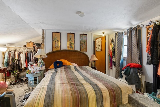 bedroom featuring a textured ceiling and lofted ceiling