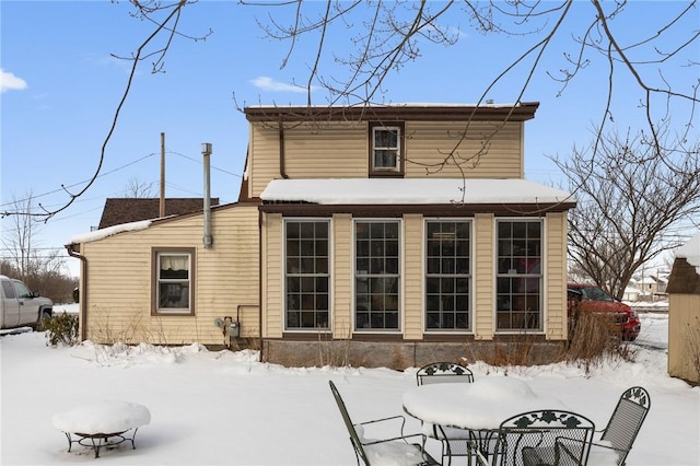 view of snow covered rear of property