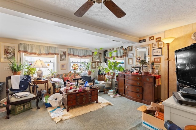 interior space with ceiling fan, a textured ceiling, and beamed ceiling