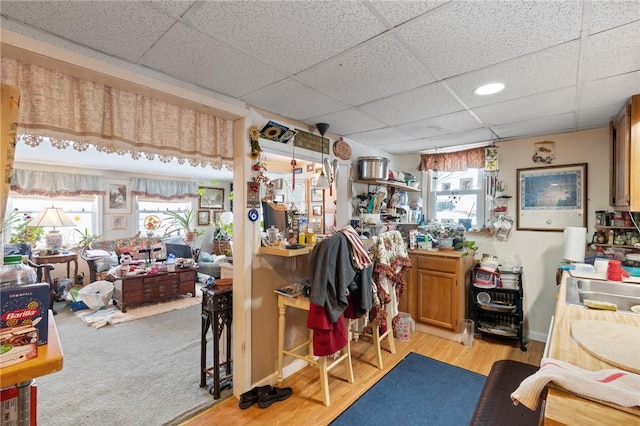 office space featuring sink, light hardwood / wood-style floors, and a drop ceiling