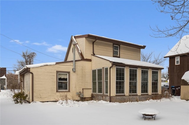 view of snow covered rear of property