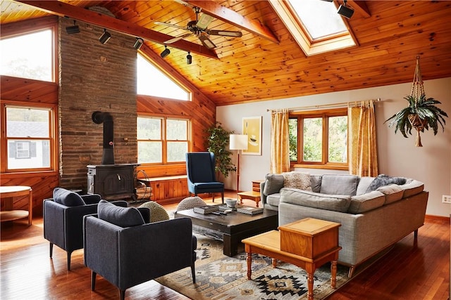 living room featuring wooden ceiling, wooden walls, high vaulted ceiling, and a wood stove